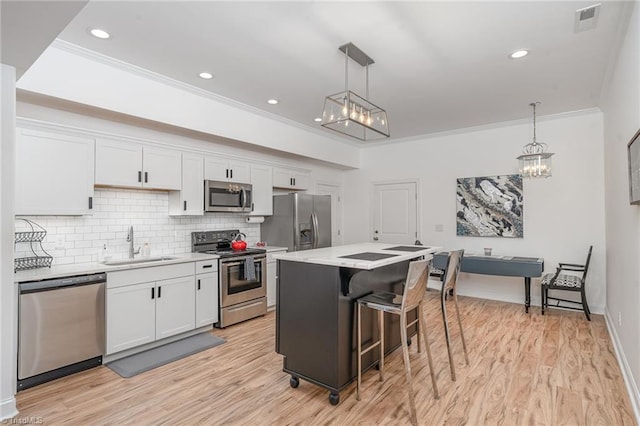 kitchen featuring white cabinets, decorative light fixtures, sink, and stainless steel appliances