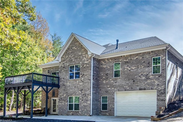 rear view of house with a garage and a wooden deck