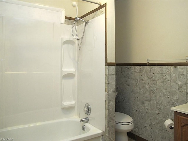 full bathroom featuring toilet, tile walls, tub / shower combination, and vanity