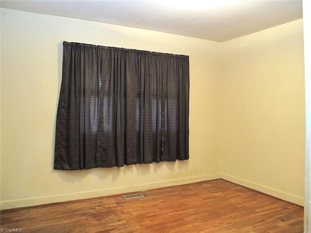 unfurnished room with hardwood / wood-style flooring