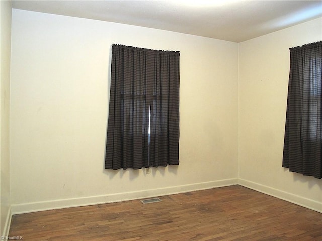 unfurnished room with dark hardwood / wood-style flooring