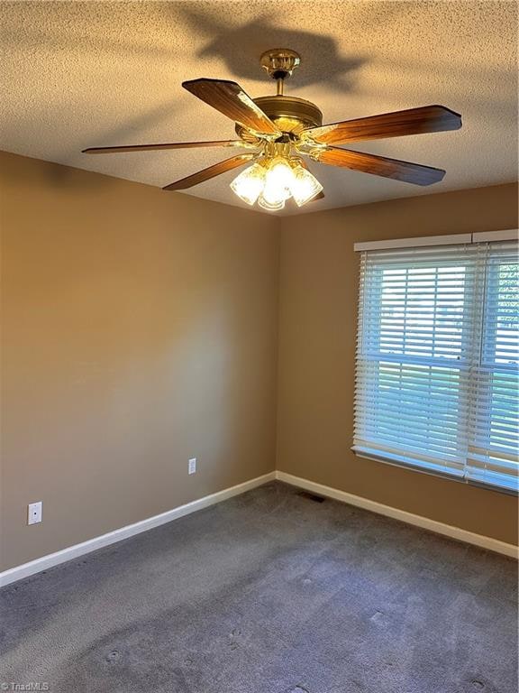 carpeted empty room featuring ceiling fan and a textured ceiling