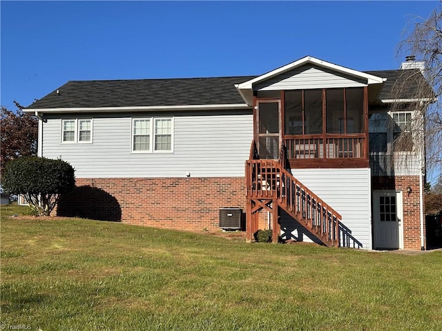 back of house with a lawn and a sunroom