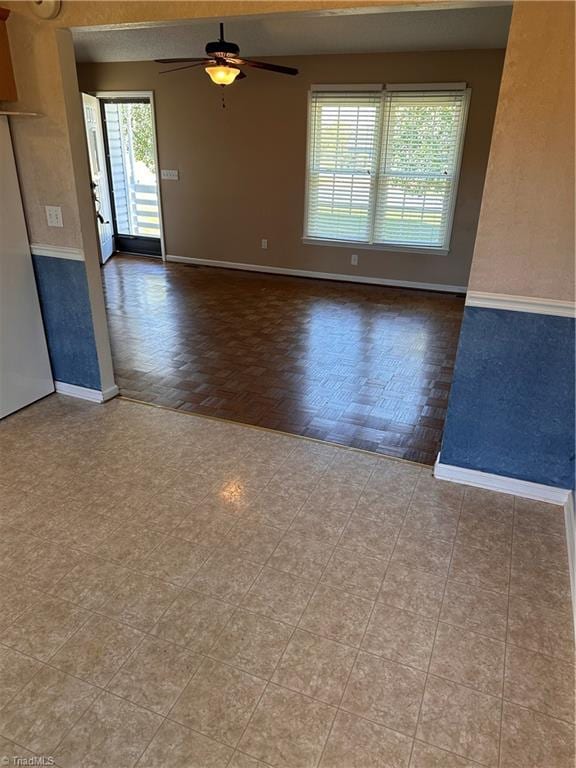 spare room with light parquet floors, a wealth of natural light, and ceiling fan