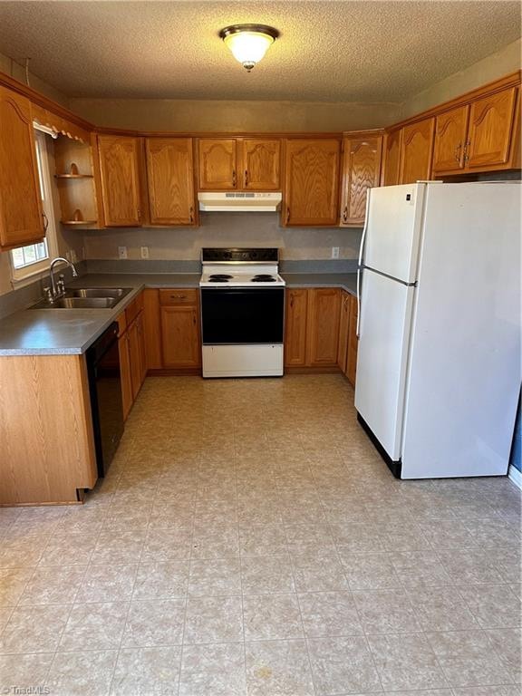 kitchen with a textured ceiling, white appliances, and sink