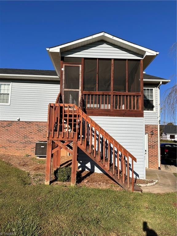 back of house featuring a lawn and a sunroom