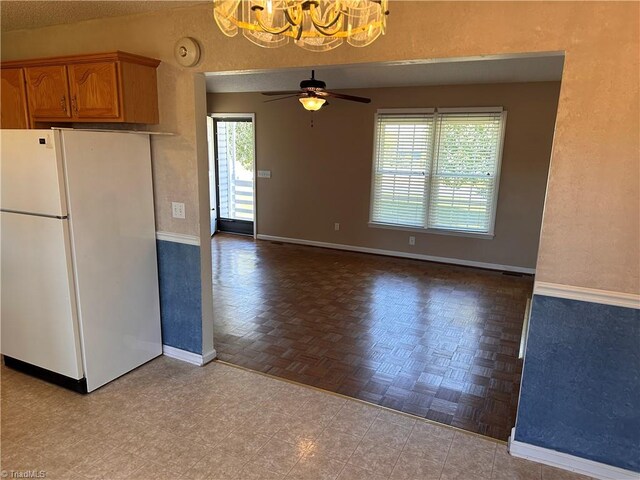 kitchen with a textured ceiling, light parquet flooring, ceiling fan with notable chandelier, and white refrigerator