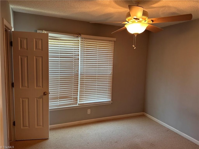 carpeted empty room featuring ceiling fan and a textured ceiling