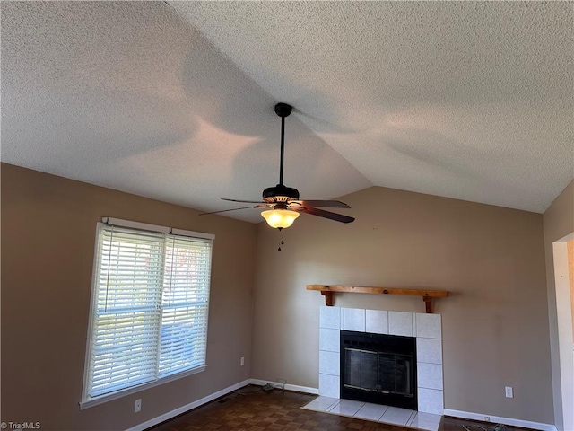 unfurnished living room with ceiling fan, parquet flooring, vaulted ceiling, a textured ceiling, and a fireplace