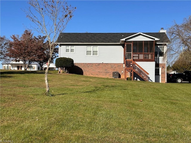 view of home's exterior featuring a lawn, a sunroom, and cooling unit