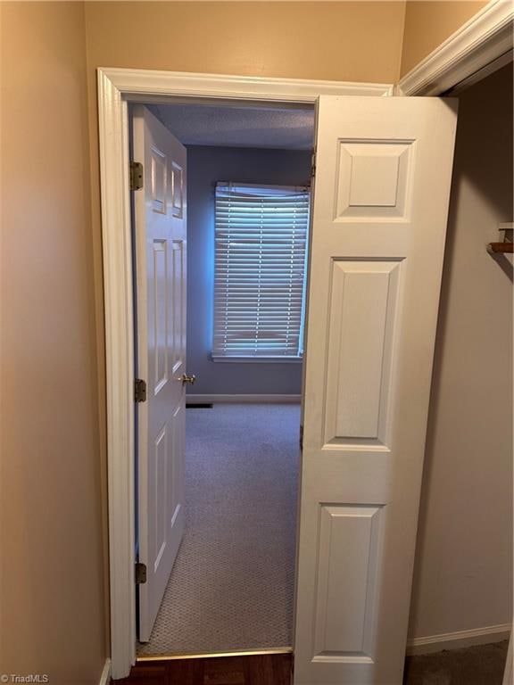 hallway with dark carpet