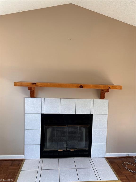 details with a tile fireplace and hardwood / wood-style flooring