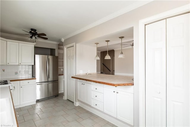 kitchen featuring white cabinets, stainless steel fridge, backsplash, and pendant lighting