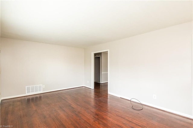 unfurnished room with dark wood-type flooring