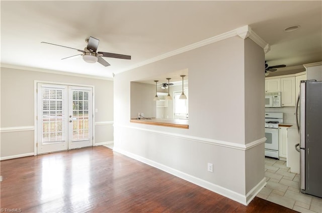 spare room featuring ceiling fan, french doors, ornamental molding, and light wood-type flooring