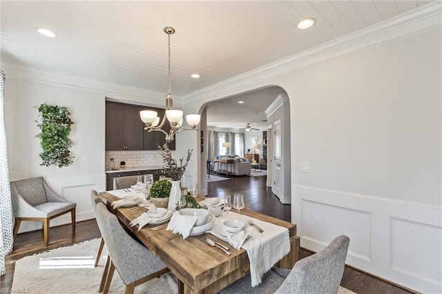 dining space featuring ceiling fan with notable chandelier, dark hardwood / wood-style floors, and crown molding