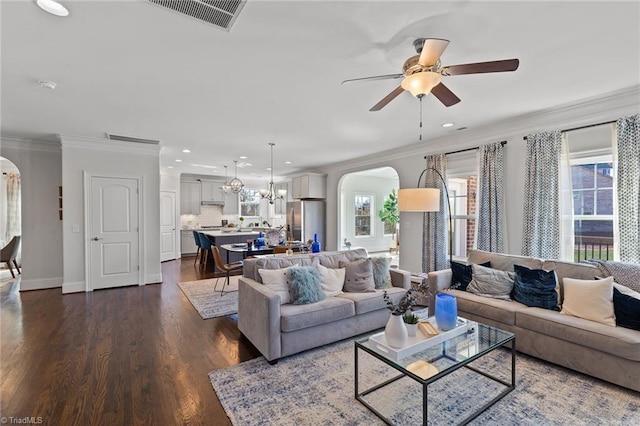 living room with dark hardwood / wood-style flooring, ceiling fan with notable chandelier, and crown molding