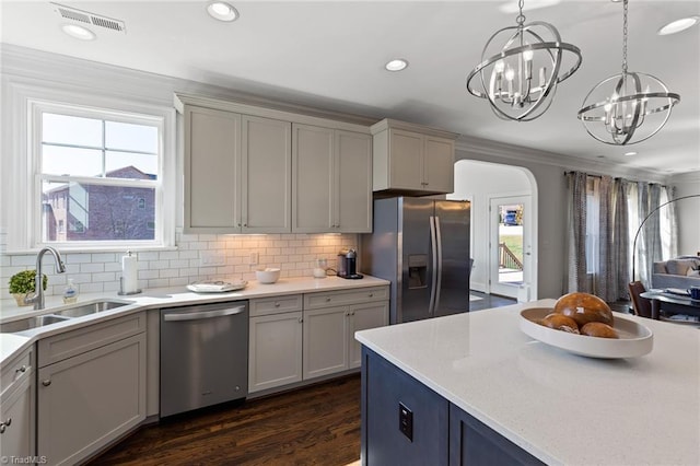 kitchen with backsplash, sink, decorative light fixtures, a notable chandelier, and stainless steel appliances