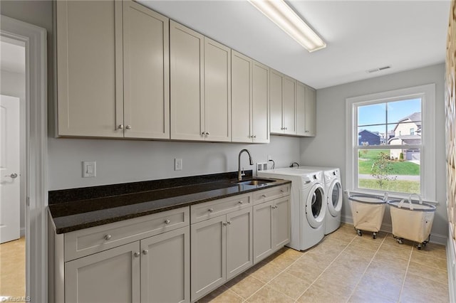 laundry area featuring cabinets, light tile patterned floors, separate washer and dryer, and sink