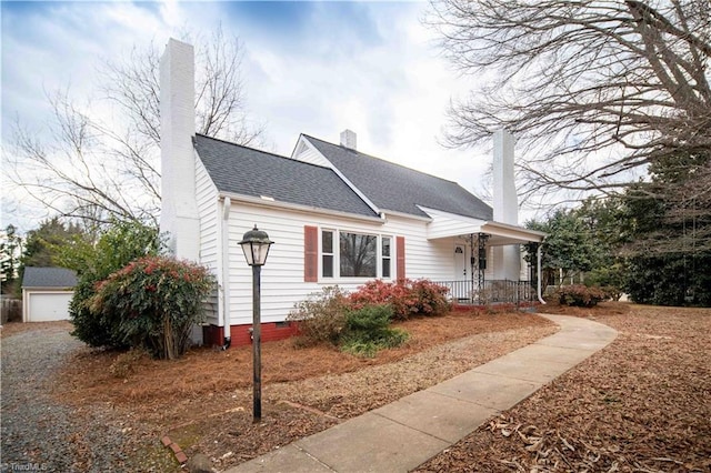 view of front of home featuring a garage, an outdoor structure, and a porch