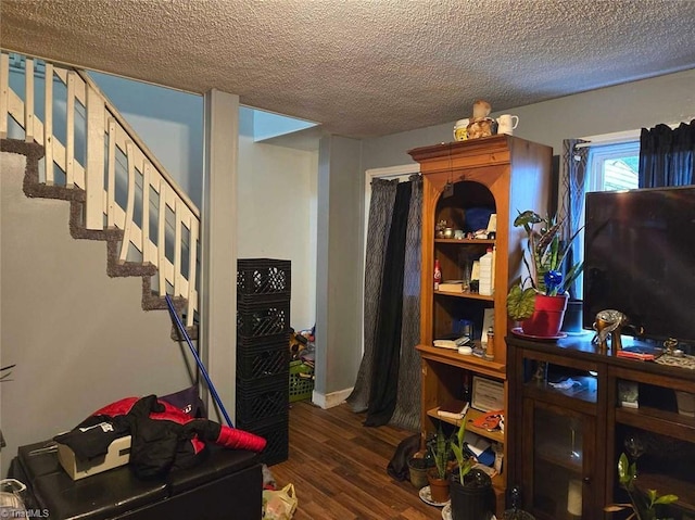 interior space featuring dark wood-type flooring and a textured ceiling