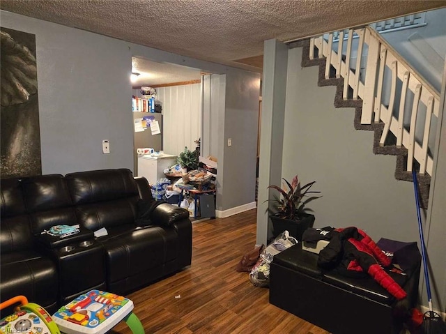 living room with a textured ceiling and dark hardwood / wood-style floors