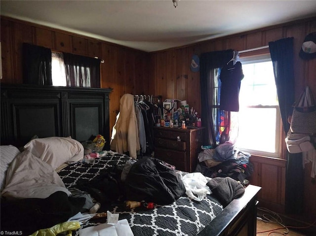 bedroom with multiple windows and wooden walls