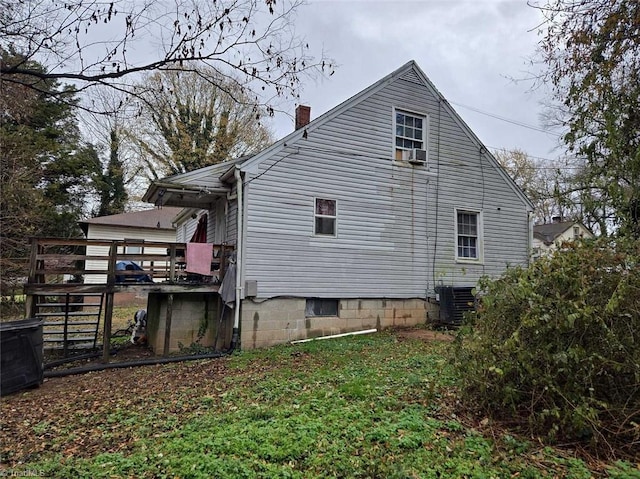 view of side of property featuring cooling unit and a wooden deck