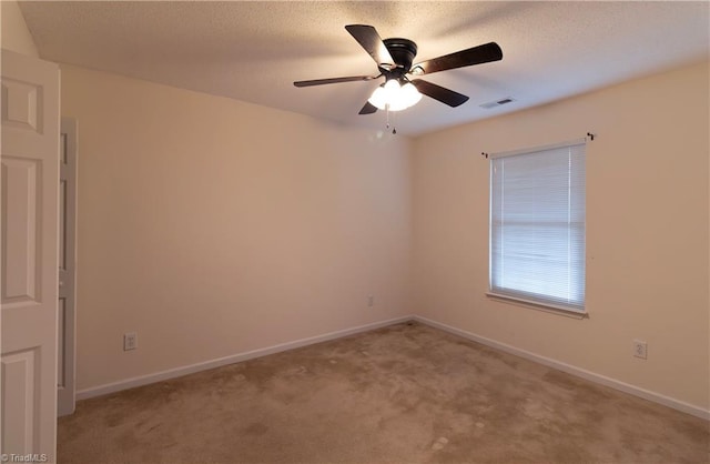 spare room featuring light colored carpet and ceiling fan