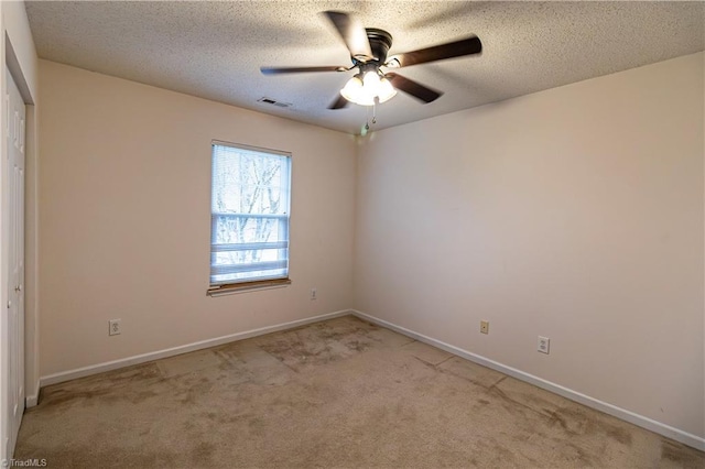 carpeted empty room with ceiling fan and a textured ceiling