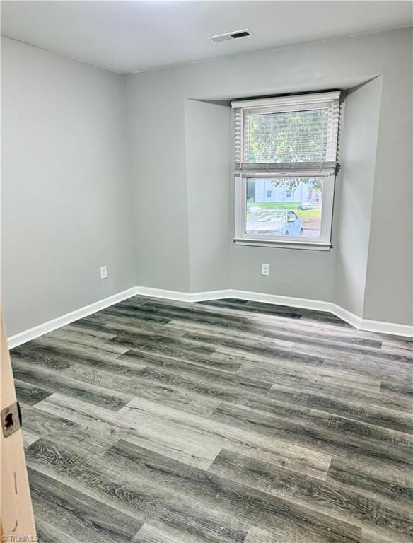 empty room featuring wood finished floors and baseboards