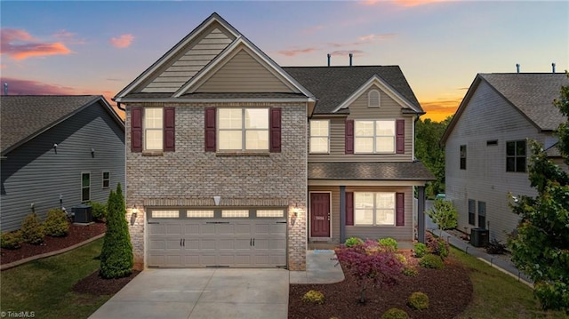 traditional-style home featuring driveway, central AC, and an attached garage