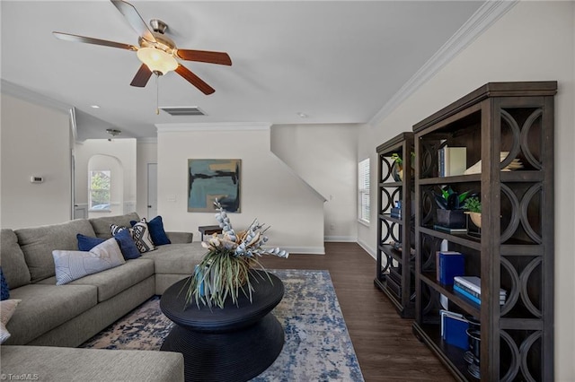 living area featuring plenty of natural light, ornamental molding, dark wood-type flooring, a ceiling fan, and baseboards