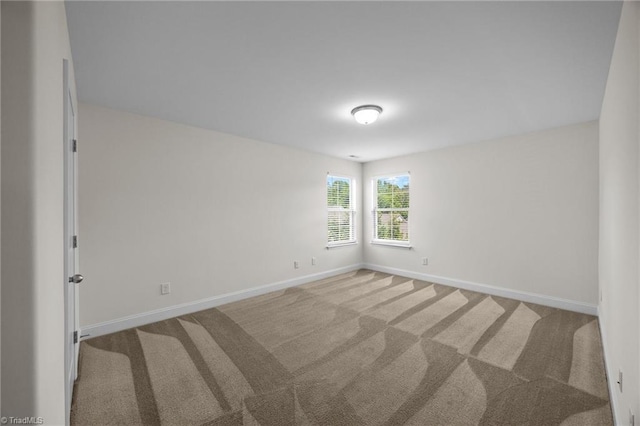 empty room with baseboards and carpet flooring