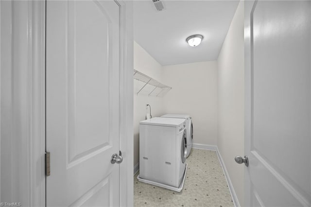 laundry room featuring independent washer and dryer, baseboards, and light floors