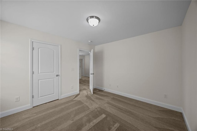 unfurnished bedroom with carpet flooring and baseboards