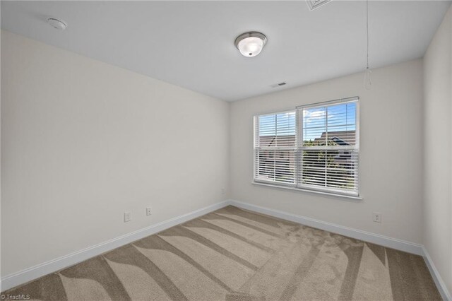 carpeted empty room featuring baseboards