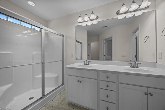bathroom featuring a shower stall and double vanity
