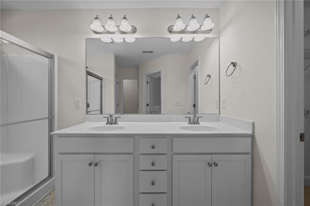 bathroom featuring double vanity and a shower stall
