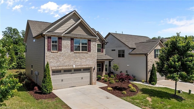 craftsman house with driveway, an attached garage, a front lawn, and brick siding