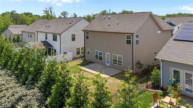 rear view of property featuring a patio, a residential view, a fenced backyard, and roof with shingles
