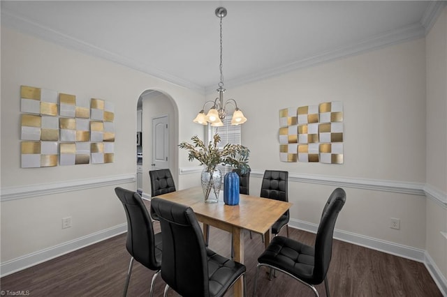 dining area with wood finished floors, a chandelier, arched walkways, ornamental molding, and baseboards