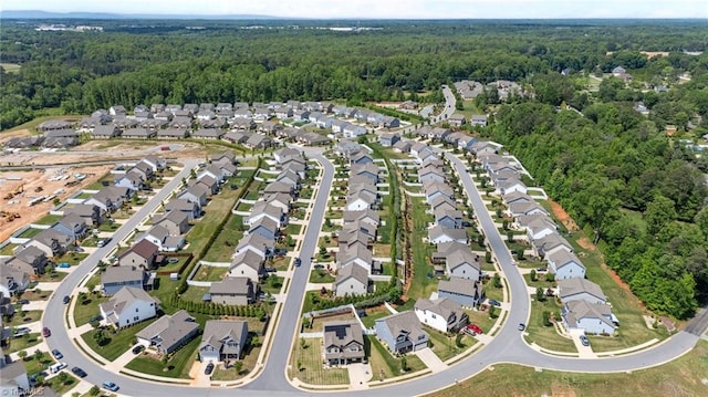 aerial view of property's location featuring a heavily wooded area and nearby suburban area