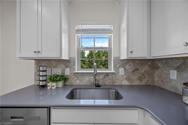 kitchen featuring a sink, dishwasher, white cabinets, and backsplash