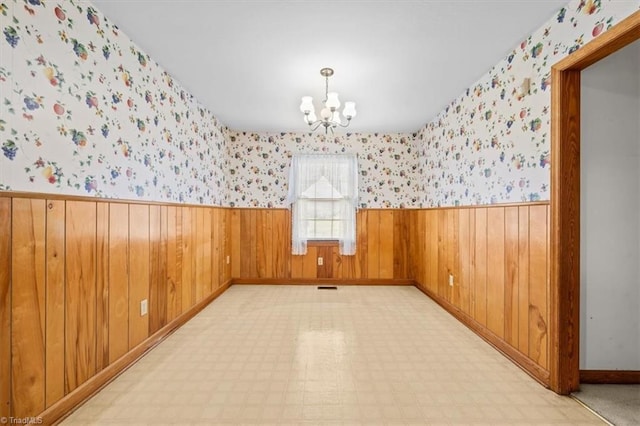 6277 Bennett Rd, Seagrove, NC 27341 - unfurnished room with a wainscoted wall, a chandelier, wallpapered walls, baseboards, and wood walls