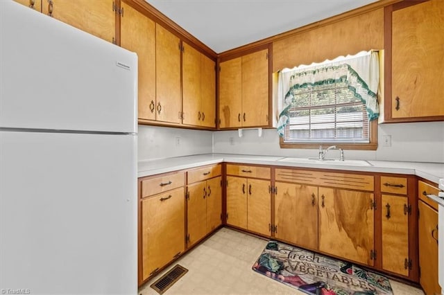 6277 Bennett Rd, Seagrove, NC 27341 - kitchen with freestanding refrigerator, light countertops, light floors, a sink, and brown cabinetry