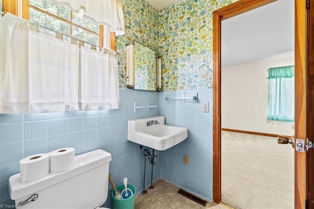 6277 Bennett Rd, Seagrove, NC 27341 - bathroom with wallpapered walls, plenty of natural light, tile walls, toilet, and wainscoting
