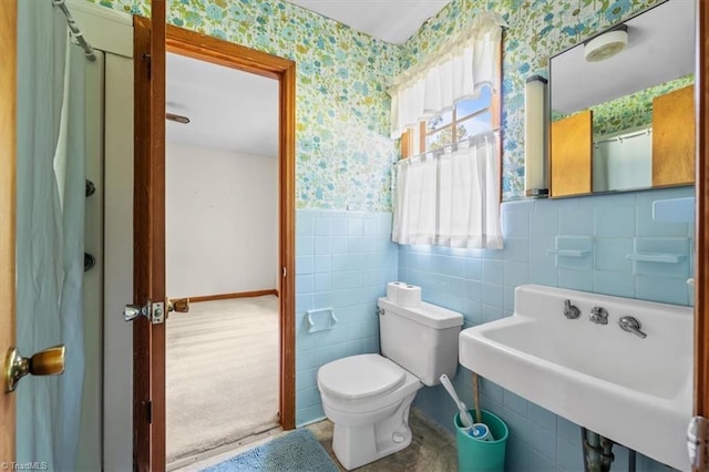 6277 Bennett Rd, Seagrove, NC 27341 - bathroom featuring wallpapered walls, a wainscoted wall, toilet, a sink, and tile walls