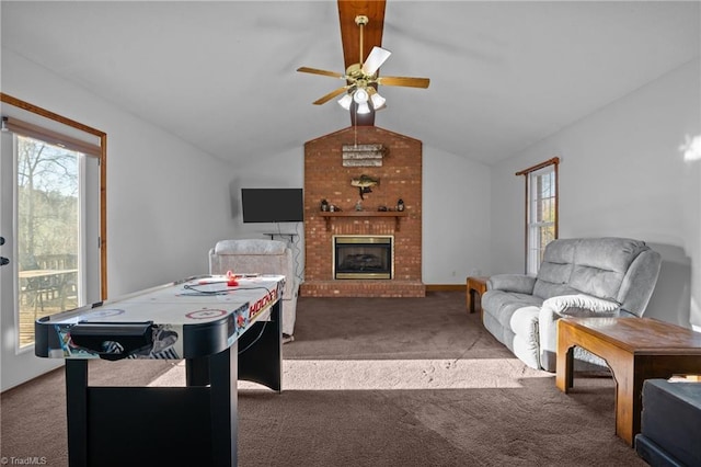 living room featuring a brick fireplace, vaulted ceiling, plenty of natural light, and dark colored carpet