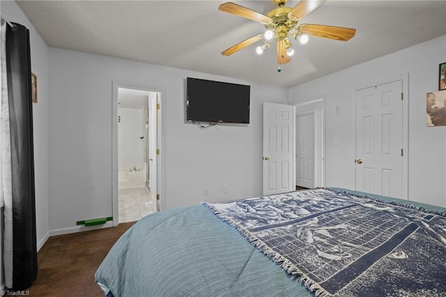 bedroom with ceiling fan, dark carpet, and ensuite bath